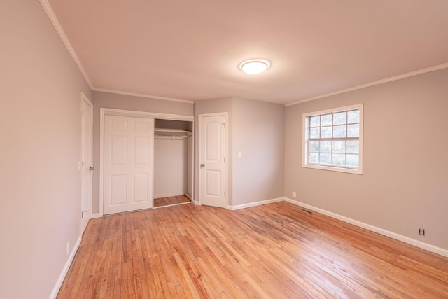 unfurnished bedroom with light hardwood / wood-style flooring, a closet, and ornamental molding