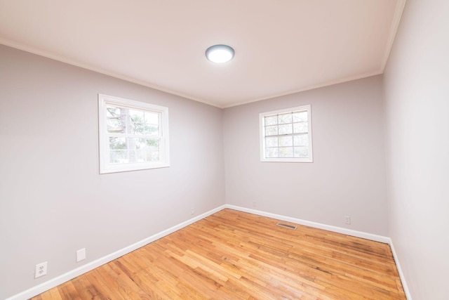 spare room featuring ornamental molding, hardwood / wood-style floors, and plenty of natural light