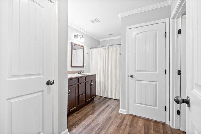 bathroom featuring vanity, crown molding, and hardwood / wood-style flooring