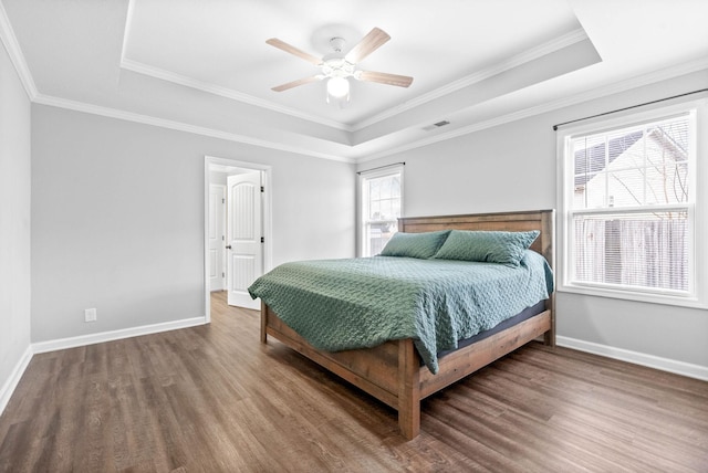 bedroom featuring ceiling fan, ornamental molding, and a tray ceiling