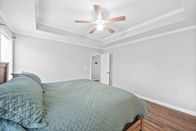 bedroom featuring crown molding, hardwood / wood-style floors, a tray ceiling, and ceiling fan