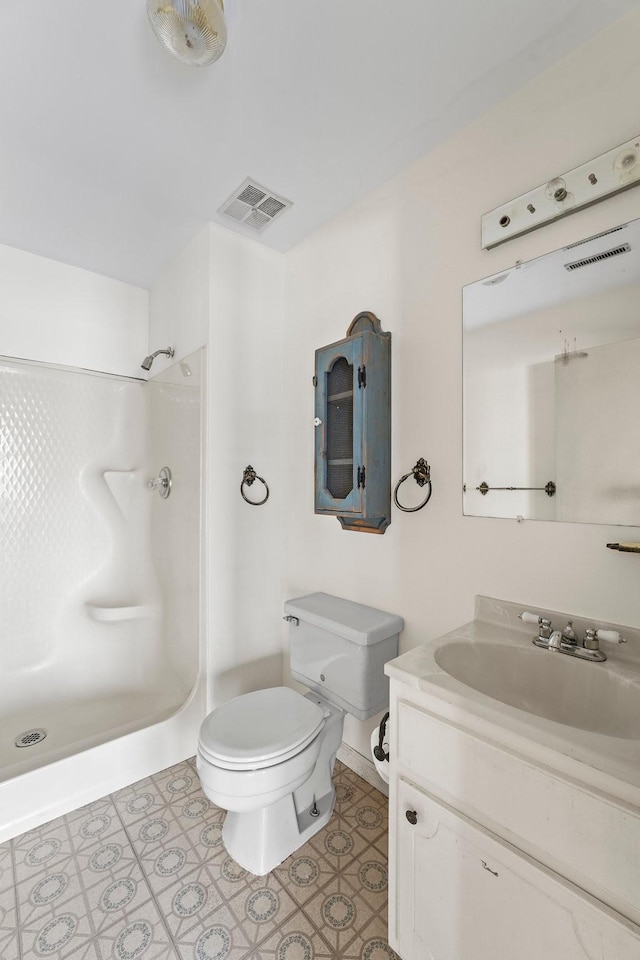 bathroom with vanity, toilet, and a shower