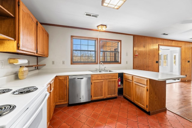 kitchen with sink, wood walls, stainless steel dishwasher, ornamental molding, and kitchen peninsula