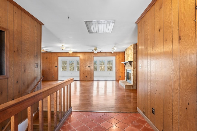 hallway featuring tile patterned floors and wooden walls