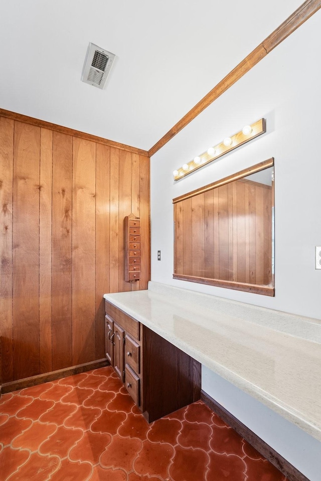 bathroom with vanity, crown molding, and wood walls