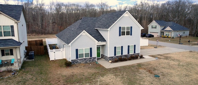 view of front of house with a front lawn and central air condition unit