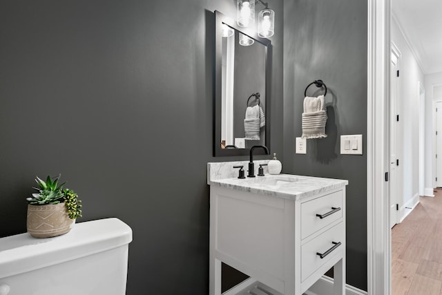 bathroom with vanity, wood-type flooring, and toilet