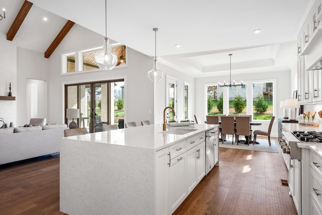 kitchen featuring sink, white cabinets, and a center island with sink