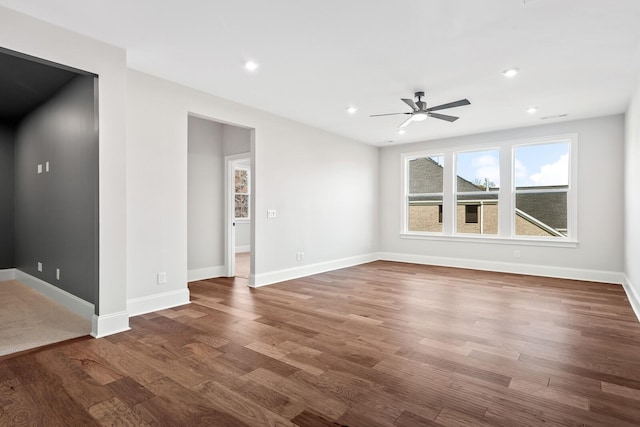 unfurnished living room featuring dark wood-type flooring and ceiling fan