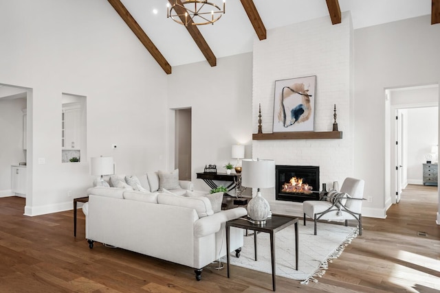 living room featuring wood-type flooring, high vaulted ceiling, a fireplace, and beam ceiling