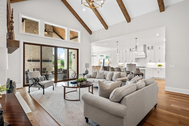 living room featuring beamed ceiling, a chandelier, high vaulted ceiling, and light hardwood / wood-style flooring