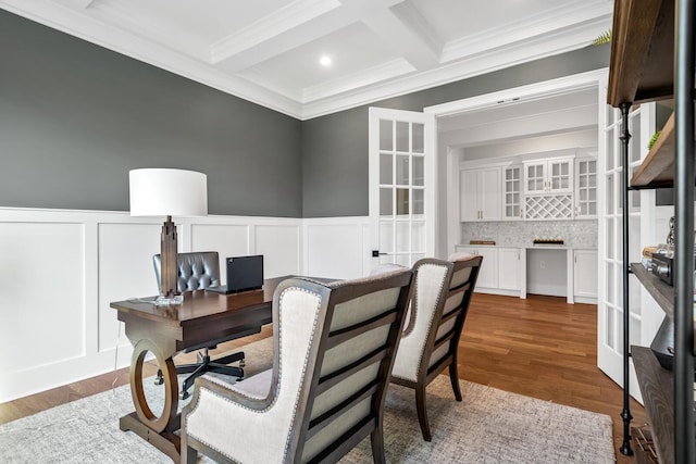 office space featuring beamed ceiling, wood-type flooring, coffered ceiling, and crown molding