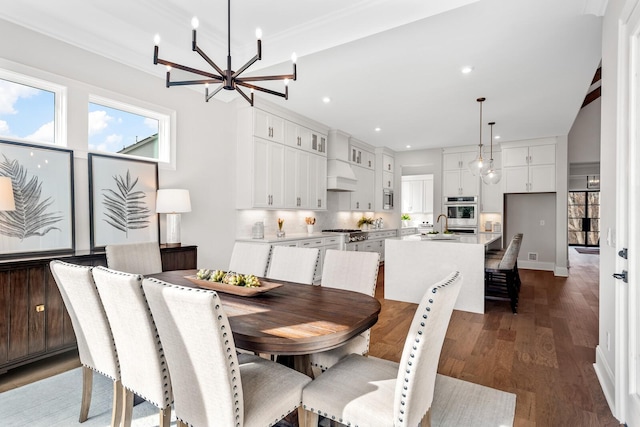 dining space with an inviting chandelier, ornamental molding, and dark wood-type flooring