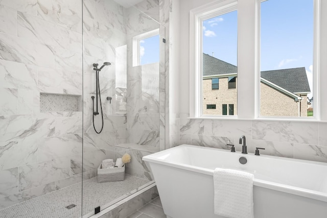 bathroom featuring a healthy amount of sunlight and separate shower and tub