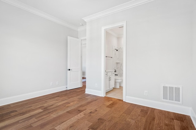 unfurnished bedroom with ornamental molding, connected bathroom, and light hardwood / wood-style flooring