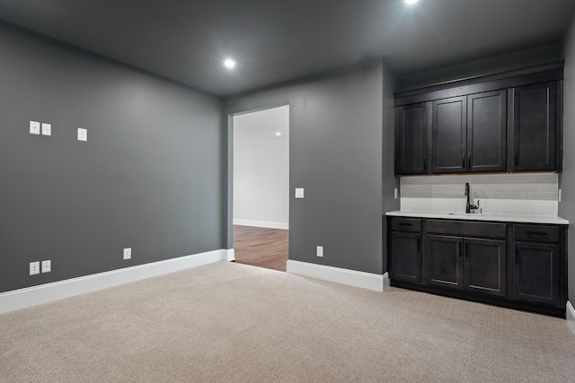 kitchen with tasteful backsplash, sink, and light colored carpet