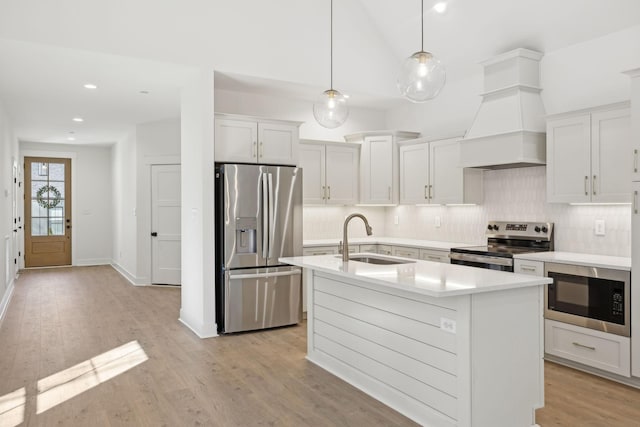 kitchen with stainless steel appliances, white cabinetry, hanging light fixtures, and sink