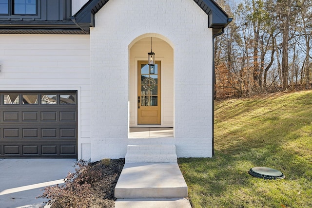 doorway to property with a garage and a lawn