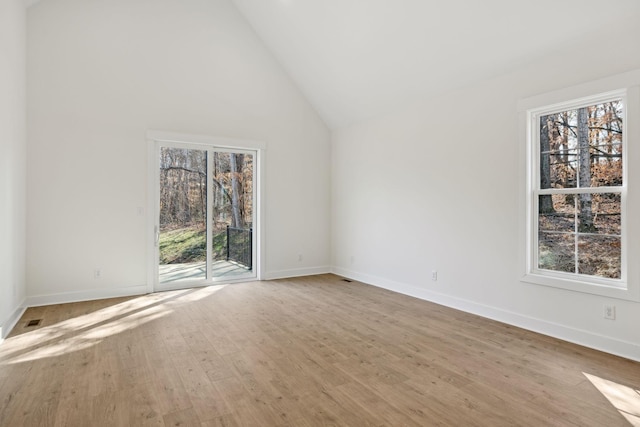 unfurnished living room featuring light hardwood / wood-style floors and high vaulted ceiling