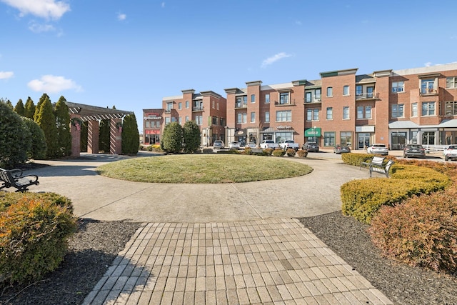 view of community featuring a pergola and a yard