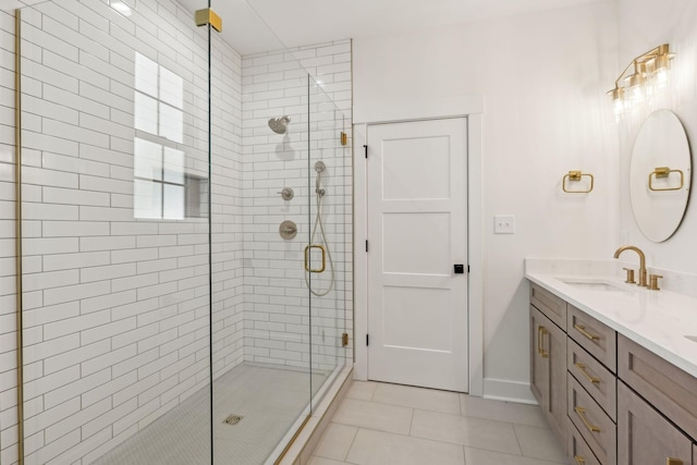 bathroom featuring a shower with door, vanity, and tile patterned floors