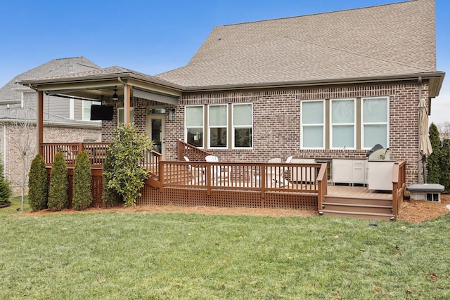 rear view of property with exterior kitchen, a wooden deck, and a yard