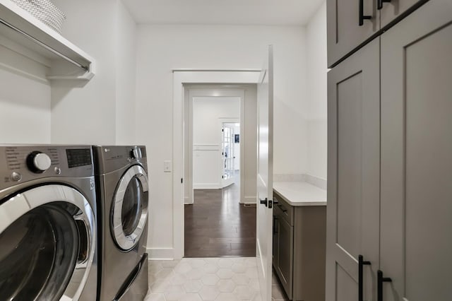 washroom featuring washer and clothes dryer, light tile patterned floors, and cabinets