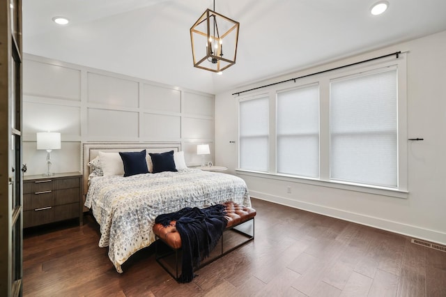 bedroom featuring a chandelier and dark hardwood / wood-style flooring