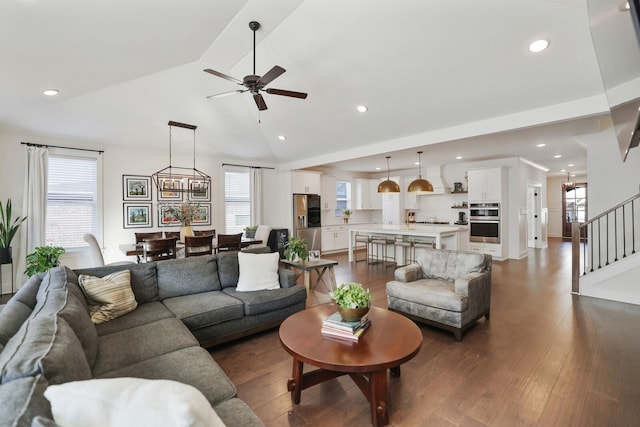 living room with vaulted ceiling, a wealth of natural light, ceiling fan, and dark hardwood / wood-style flooring