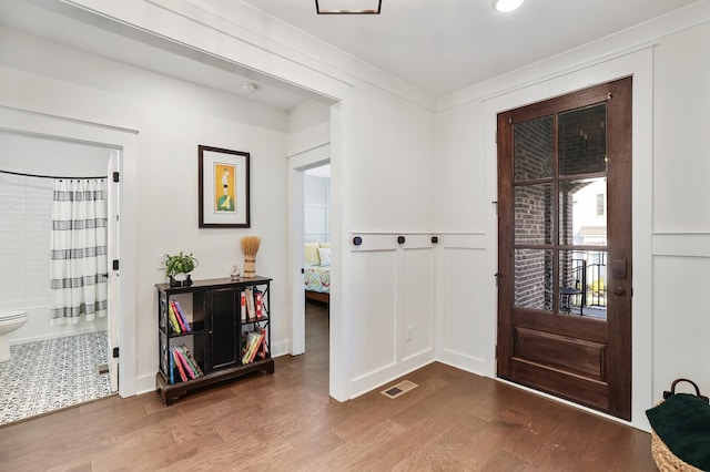 foyer with crown molding and wood-type flooring