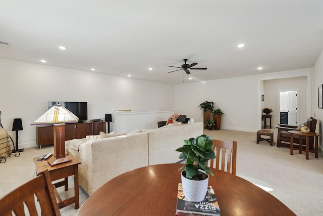 carpeted dining room with ceiling fan