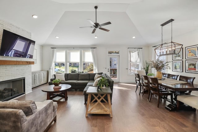 living room with ceiling fan, a fireplace, dark hardwood / wood-style flooring, and lofted ceiling