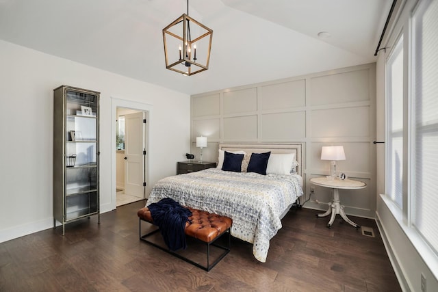 bedroom featuring an inviting chandelier, dark hardwood / wood-style floors, and vaulted ceiling