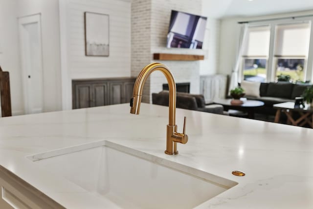 interior details featuring sink and light stone countertops