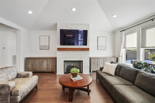 living room featuring a fireplace, vaulted ceiling, and dark hardwood / wood-style flooring