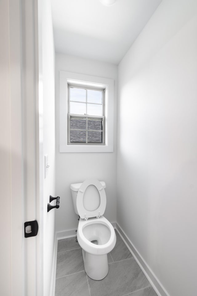 bathroom featuring toilet and baseboards