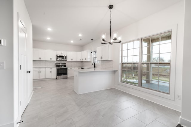 kitchen featuring a sink, white cabinets, light countertops, appliances with stainless steel finishes, and backsplash