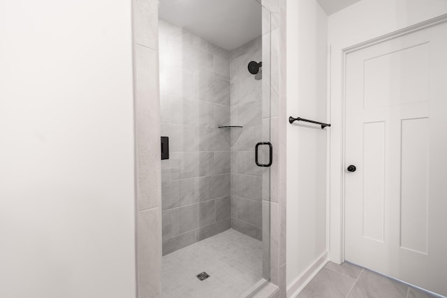 full bath featuring tile patterned flooring and a shower stall