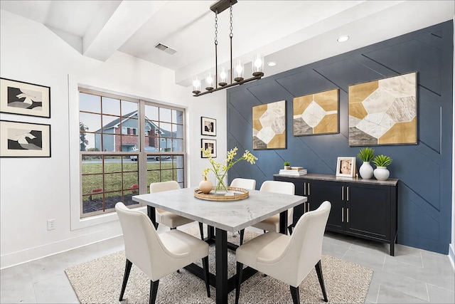 dining room with beam ceiling, light tile patterned floors, visible vents, an accent wall, and baseboards