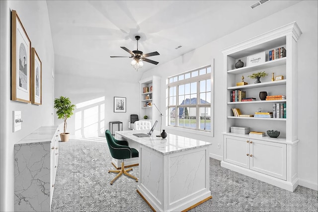 office space featuring ceiling fan, light carpet, visible vents, baseboards, and built in features