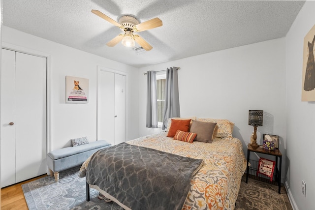 bedroom with ceiling fan, a textured ceiling, and wood-type flooring