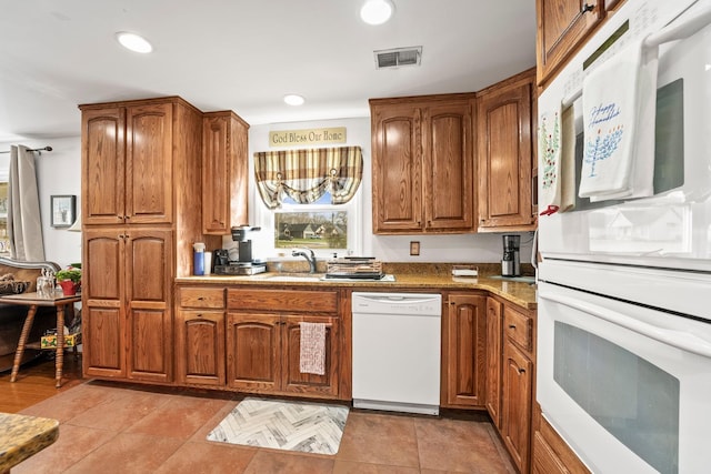 kitchen featuring sink, white appliances, light stone countertops, and light tile patterned flooring