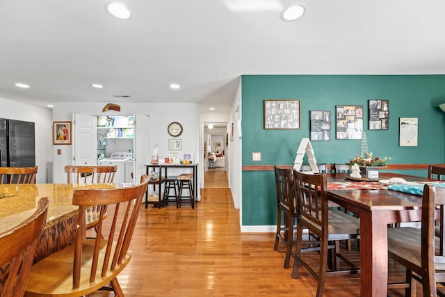 dining room with light hardwood / wood-style floors and washer and clothes dryer