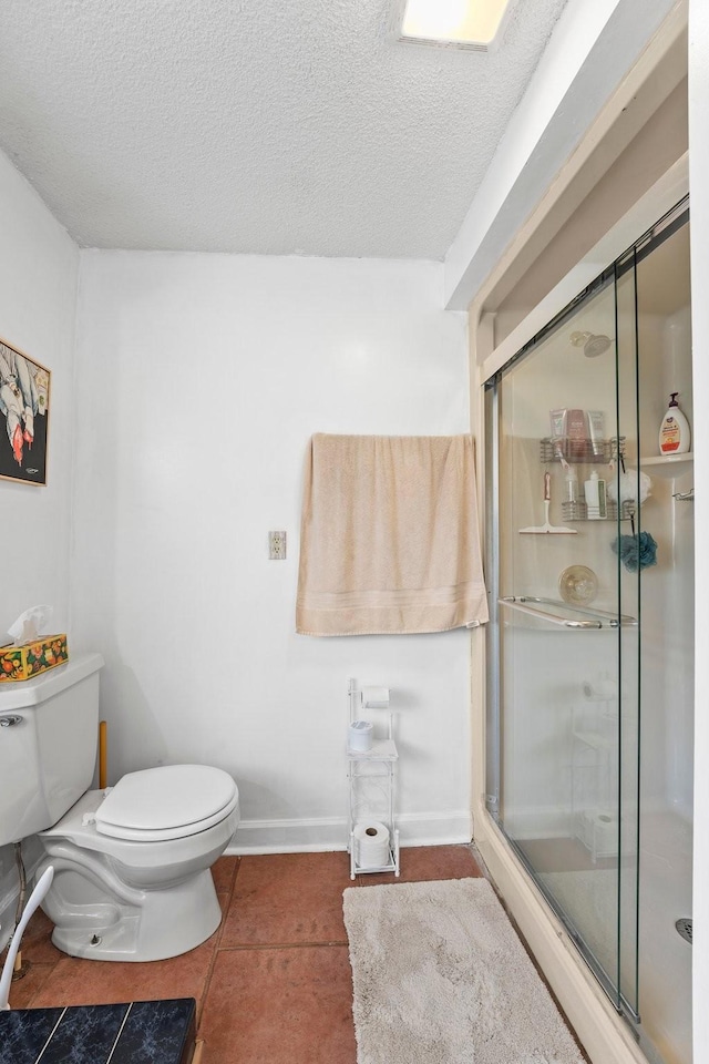 bathroom with a textured ceiling, toilet, tile patterned flooring, and an enclosed shower