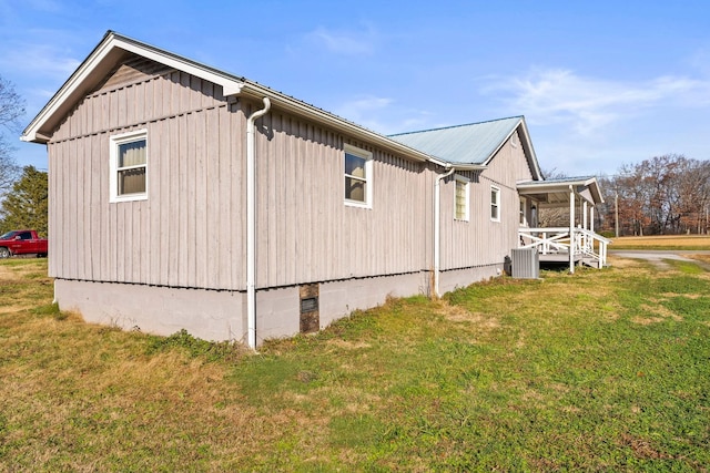 view of side of home with a porch and a yard