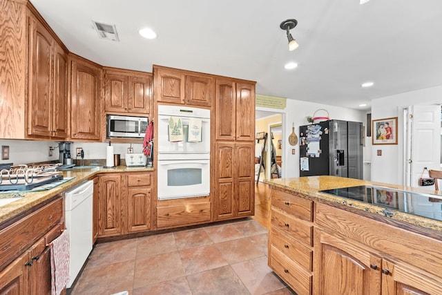 kitchen with light stone counters and appliances with stainless steel finishes