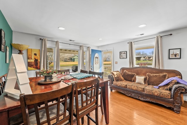 dining space with a healthy amount of sunlight and light hardwood / wood-style floors