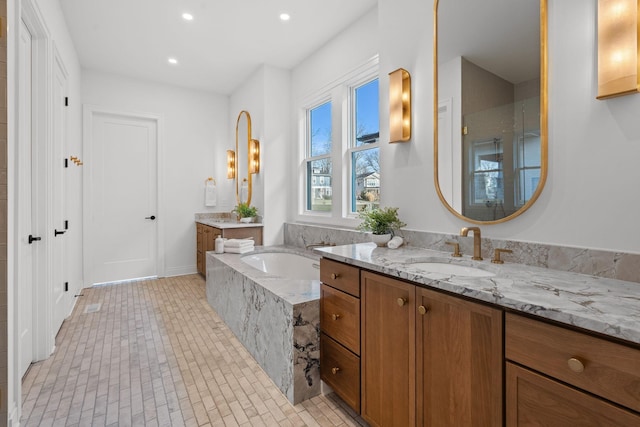 bathroom with vanity, a relaxing tiled tub, and tile patterned floors