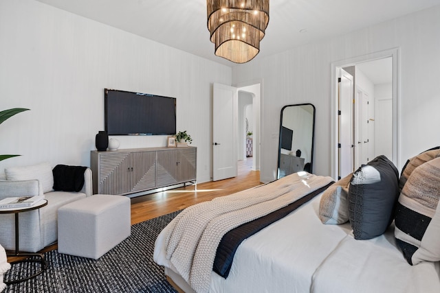 bedroom with a chandelier and hardwood / wood-style floors