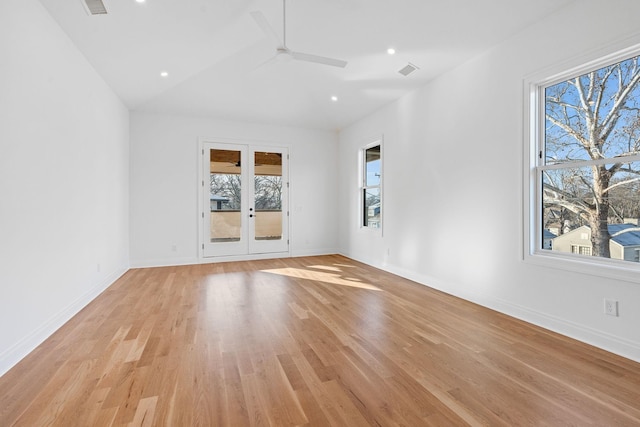 empty room featuring vaulted ceiling, light hardwood / wood-style floors, french doors, and ceiling fan